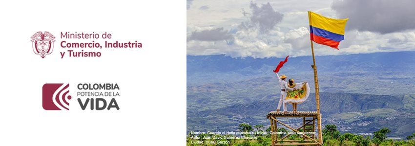 Bailarines en una plataforma con una bandera de Colombia